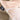 Close-up of a pale blush pink fabric product, likely a pillow or cushion cover, with a black sewn-in brand tag reading 'LIFE IS A JAZZ @' and a small metallic circular detail.