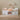White children's bed with storage drawers and bedding in a room setting.