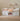 White children's bed with storage drawers and bedding in a room setting.