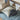Children's bed with blue bedding and patterned pillow, wooden shelf in the background
