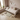 Children's bedroom with a bed, toys, and a plant on a wooden floor.