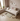 Children's bedroom with a bed, toys, and a plant on a wooden floor.